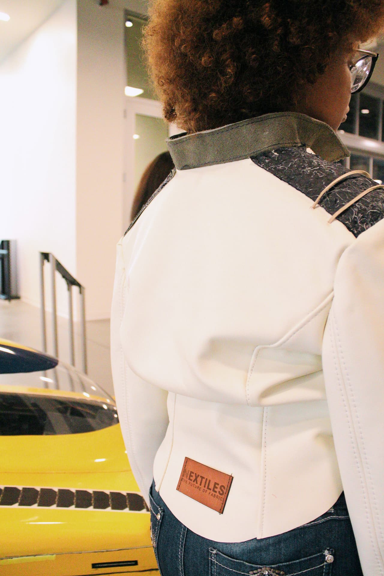 Back view of a cream jacket with a BioSpoke biomaterial collar and shoulder panel
