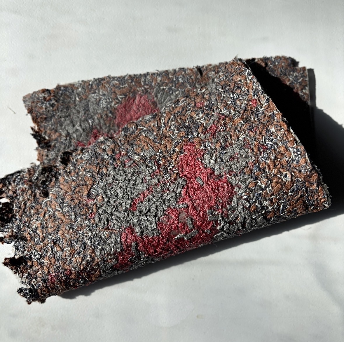 Algae-bonded textile pulp drying in a wooden mold