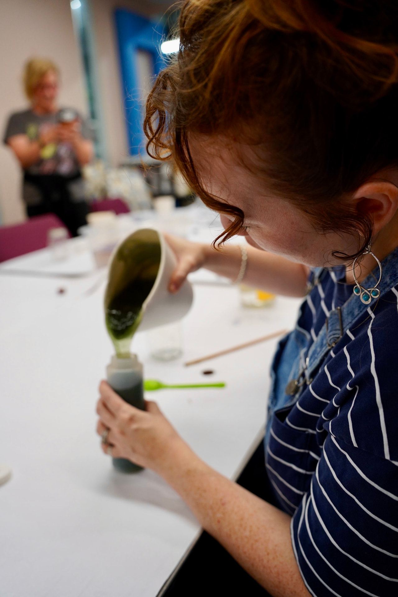 Workshop participant pouring a green biomaterial mixture